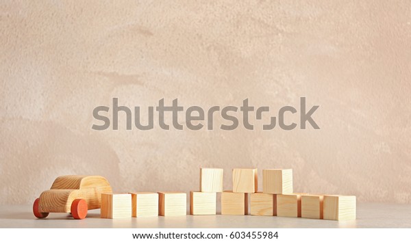 Cubes with space for text and wooden toy car\
on light background