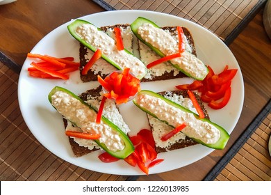 Cucumber Cut In Half With Fresh Quark And Pepper Strips Stuffed On Black Bread. A Low-calorie Meal And Vegan Entree