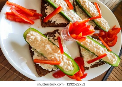 Cucumber Cut In Half With Fresh Quark And Pepper Strips Stuffed On Black Bread. A Low-calorie Meal And Vegan Entree