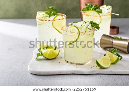Cucumber margarita with lime and spicy rim, refreshing spring cocktail with copy space