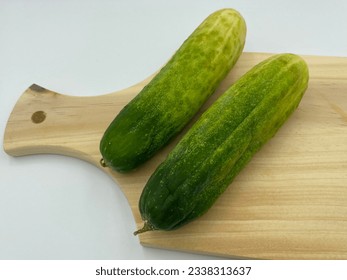 Cucumber on a wooden cookware - Shutterstock ID 2338313637