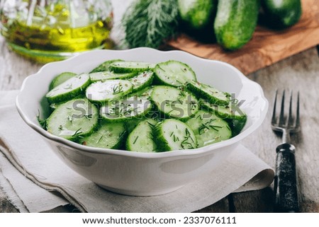 Cucumber salad. Fresh green cucumbers and dill salad bowl with olive oil