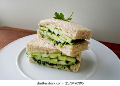 Cucumber Sandwich Made With Whole Wheat Bread, Cream Cheese And Coriander Chutney. Finger Sandwiches On A White Plate For English Afternoon Tea. Square Sandwich Cut In Half.