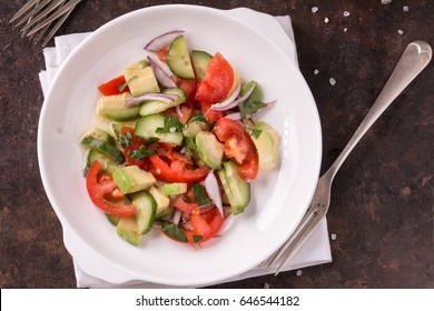 Cucumber Tomato And Avocado Salad. Dark Background. Vegetable Salad. 
