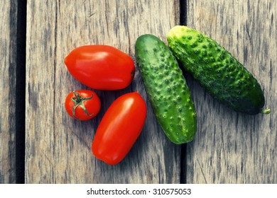 Cucumbers and tomatoes.The background of the tree structure.Vegetable growing.Photo toned in retro style.