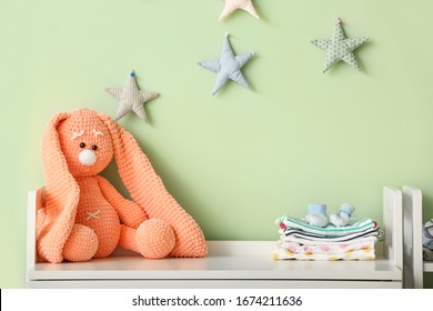 Cuddly Toy With Baby Clothes On Table In Children's Room