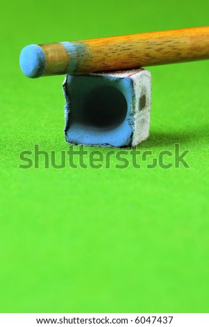 cue stick wit chalk block, shallow depth of field
