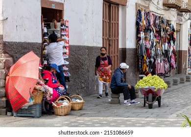 Cuenca, Ecuador - February 27, 2022: Street venders at the street of city Cuenca in Ecuador. Women sell eggs and man sells grapes
