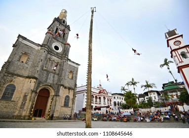 Cuetzalan Del Progreso, Puebla Mexico. May 23, 2018. Flying Dancers Performing The Dance Of The Flyers Ritual Around The 30 Meter Tree Pole Front Of The Parroquia De San Francisco De Asís. 