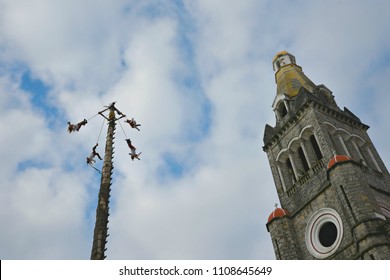 Cuetzalan Del Progreso, Puebla Mexico. May 23, 2018. Flying Dancers Performing The Dance Of The Flyers Ritual Around The 30 Meter Tree Pole Front Of The Parroquia De San Francisco De Asís. 