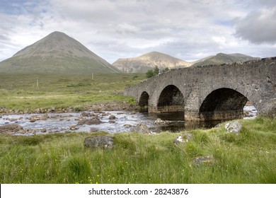 Cuillin area in Highland Scotland UK with an ancient bridge and mountains in HDR