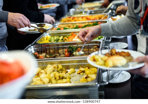 Cuisine Culinary Buffet Dinner Catering\
Dining Food Celebration Party Concept. Group of people in all you\
can eat catering buffet food indoor in luxury restaurant with meat\
and vegetables.