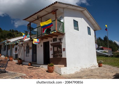 CUITIVA, BOYACA - NOVEMBER 30 OF 2020 Representation Of An Old Colombian Boyaca Town House With Two Floors, Ceramic Roofs, Ceramic Pots And Colombian Flags In Sunny Day