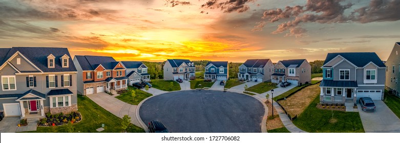 Cul de sac classic dead end street surrounded by luxury two story single family homes in a new residential East Coast USA real estate development neighborhood with dramatic colorful sunset sky