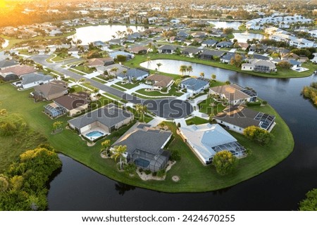Cul de sac street dead end at sunset and private residential houses in rural suburban sprawl area in North Port, Florida. Upscale suburban homes with large waterfront backyards