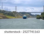 Culebra Cut with Centennial Bridge and freight ship heading towards Miraflores locks on Panama Canal.