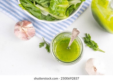 Culinary aromatic Green Herb Salad Dressing. Infused fresh Basil, parsley garlic olive oil for cooking dinner, with green salad on kitchen background copy space - Powered by Shutterstock