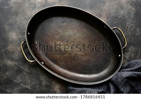 Culinary background with empty old pan on a dark slate, stone, concrete or metal background.Top view with copy space.