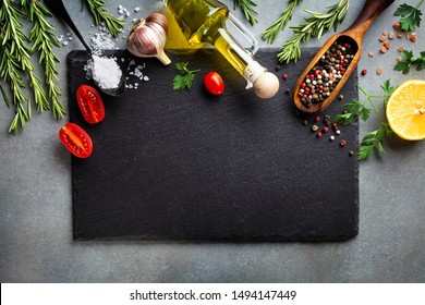 Culinary background with kitchen slate board and aromatic spices. Empty place for menu or recipe. Top view.