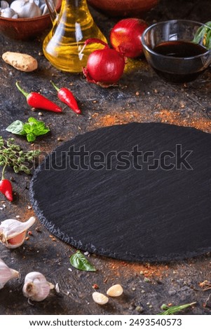 Culinary background with kitchen slate stone serving platter, olive oil and vegetables. Selective focus with copy space for text