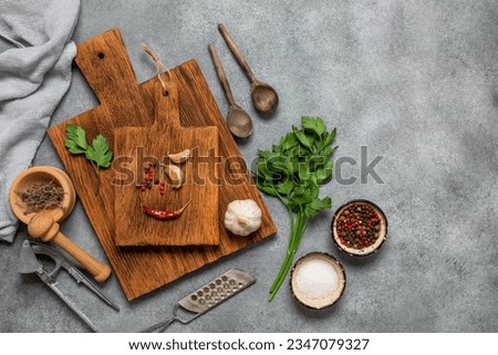 Culinary background. Kitchen utensils and tools, spices, greens on a gray concrete background. Top view, flat lay, copy space.