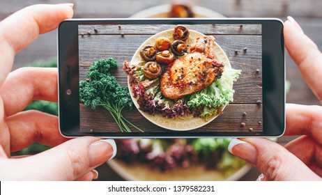 Culinary Blog. Home Cooking Hobby. Food Recipe. Closeup Of Female Hands Taking Picture Of Roasted Meat With Grilled Mushrooms.