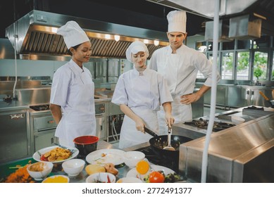 Culinary instructor teaching students wok cooking techniques in professional training kitchen