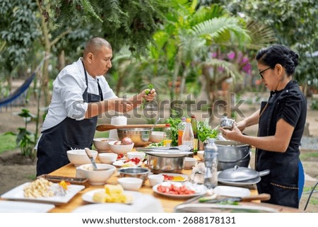Culinary professionals teaching a cooking class outdoors, focusing on fresh ingredients and healthy cuisine in a garden environment