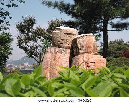 culpture of a couple embracing each other amidst the lush greenery in the royal garden of Korea