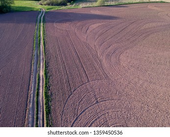 cultivated spring agriculture field and farm road, aerial
