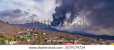 The Cumbre Vieja volcano eruption with black smoke on the Canary island of La Palma, Spain, panorama
