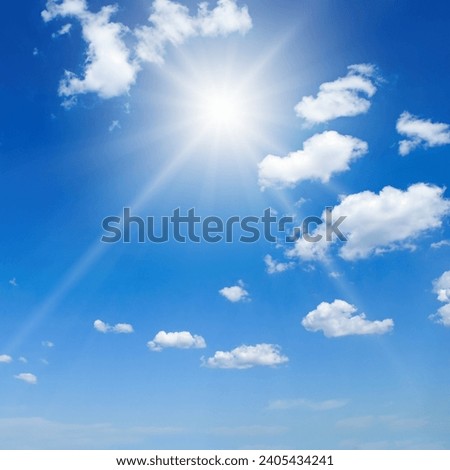 Cumulus clouds and bright sun in the blue sky.