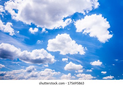 Cumulus clouds with clearly defined edges against a deep blue sky on a sunny day in summertime.