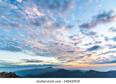 Cumulus sunset clouds with sun setting down