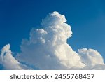 Cumulus white clouds bodies towering in clear blue sky background.