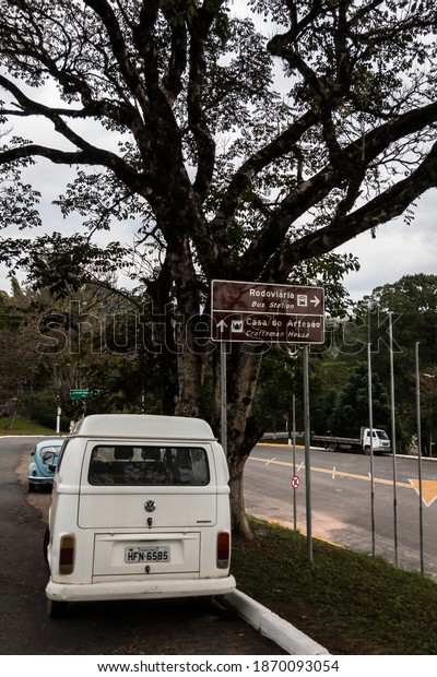 CUNHA, SAO PAULO, BRAZIL - AUG\
19, 2019: A brown landmark sign showing the directions for the Bus\
Terminal and the Craftsman House. Sign at Lavapes lane under a\
tree.