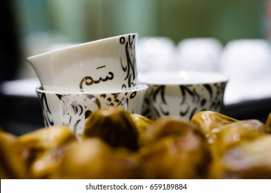 A Cup Of Arabic Coffee And Dates (the Translation Of The Text Appears On The Cup:it Is A Term Used In Saudi Arabia Means Hospitality Or It Means 