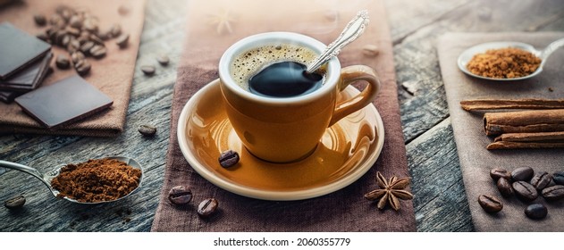 A cup of aromatic black coffee, a coffee maker, coffee beans of different varieties on the table. Morning espresso or Americano coffee for breakfast in a beautiful brown cup. - Powered by Shutterstock