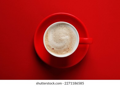 Cup with aromatic cappuccino on red background, top view - Powered by Shutterstock