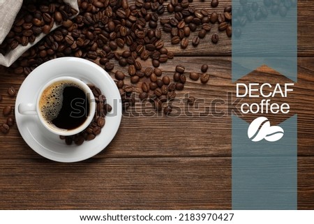 Cup of aromatic decaf coffee and beans on wooden table, flat lay