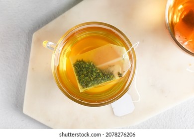 Cup of aromatic green tea on light background