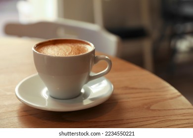 Cup of aromatic hot coffee on wooden table in cafe - Powered by Shutterstock