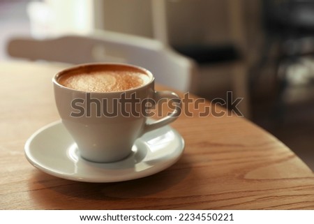 Cup of aromatic hot coffee on wooden table in cafe