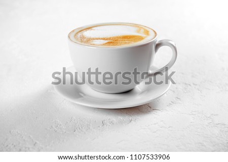 Cup of art latte on a cappuccino coffee on white background