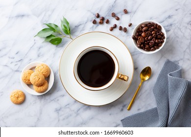 Cup of black coffee with amaretti cookies on marble table. Top view.