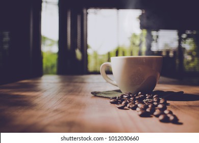 Cup Of Black Coffee And Coffee Bean On Wooden Table With Morning Lighting Top View And Side View In Coffee Shop , By Vintage Retro Hipster Color Tone , Copy Space