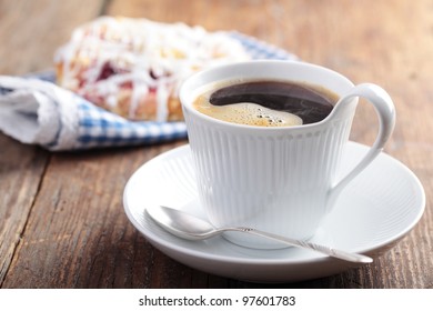 Cup Of Black Coffee And Cinnamon Roll