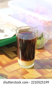 A Cup Of Black Coffee And Creamer At The Bottom Of The Glass 