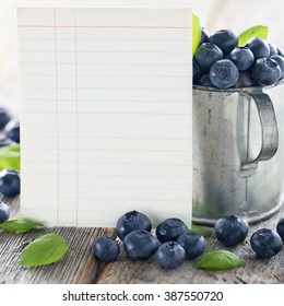 Cup Of Blueberries With A Blank Index Card For A Recipe