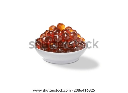 Cup of brown Pearls Bubble Tea closeup isolated on white background. Bowl of konjac 3Q boba pearl for topping milk tea drinks. Coffee caramel brown sugar flavor jelly tapioca                    